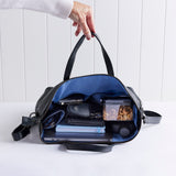 Rome leather tote in black showing items packed inside.