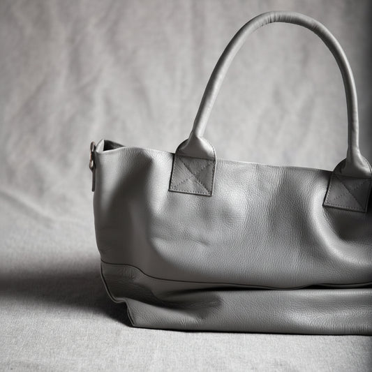 Dove grey leather handbag on a gray background